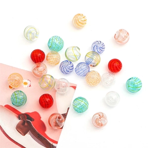 Macro detail of handmade hollow glass beads with colorful spiral stripes for DIY jewelry