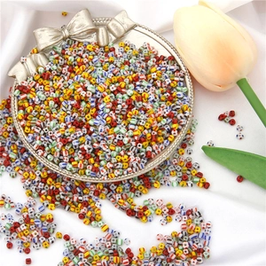 Close-up of colorful striped glass seed beads in a tray for DIY jewelry making