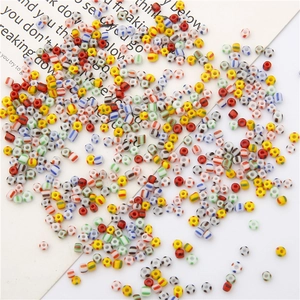 Colorful striped glass seed beads for DIY jewelry making scattered on a white background