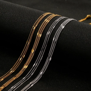 Macro shot of 18K gold and silver triple-layered sequin choker necklaces on a stand