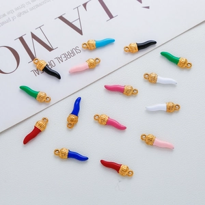 Macro view of colorful cornicello chili pendants with textured gold metal caps and rings