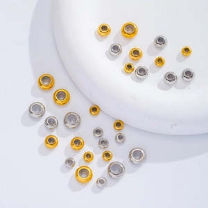 Detailed macro view of gold and silver stainless steel spacer beads in various sizes
