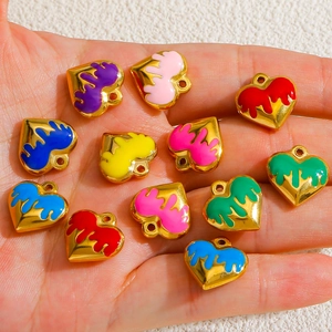 Detail of colorful enamel heart pendants for DIY jewelry making on a hand palm