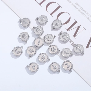 Lot de dix-sept breloques rondes en acier inoxydable avec symboles pour bijoux DIY