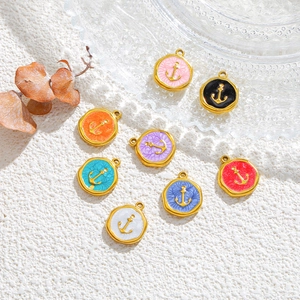 Macro shot of eight colorful enamel anchor charms in gold plating with hammer texture finish