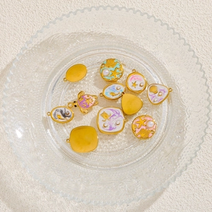 Detalle de colgantes marinos en esmalte menta y lila con perlas y bordes dorados