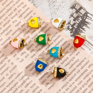 Colorful enamel heart pendants with rhinestones on vintage newspaper background