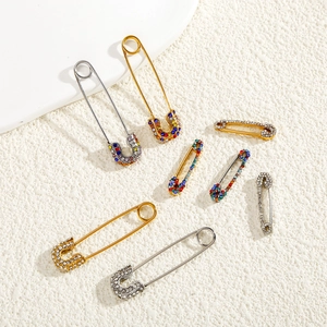 Macro detail of assorted safety pin brooches with colorful rhinestones in gold and silver