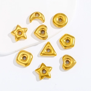 Detailed view of various golden stainless steel geometric charms and hollow spacer beads