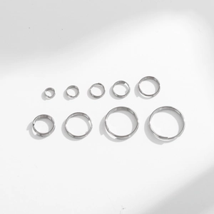 Multiple sizes of stainless steel double loop key rings arranged on a white background
