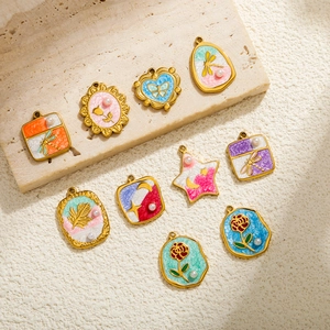 Detail van kleurrijke emaille bedels met libellen- en bloemmotieven voor DIY sieraden