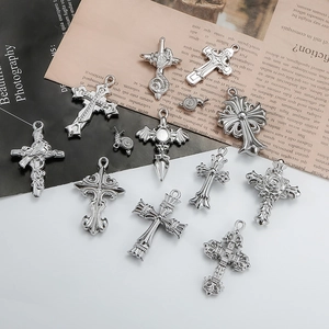 Gothic vintage silver pendants including cross, rose, and wings on a retro background