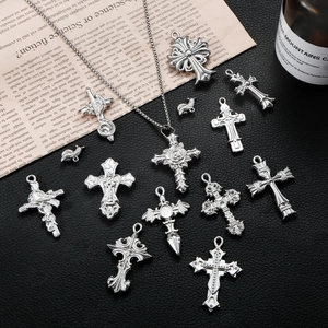 Collection of retro silver cross pendants in gothic punk style on black leather surface