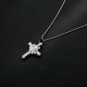 Titanium steel cross necklace with delicate rose carving on a black leather background