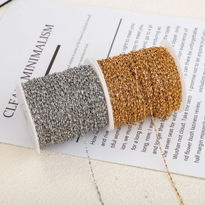 Detailed macro view of gold and silver stainless steel twist chains on white reels