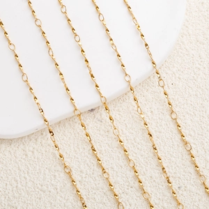 Macro shot of gold-plated stainless steel twisted spiral and micro round link chain