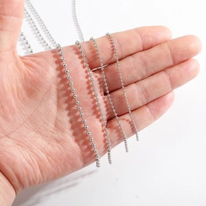 Silver stainless steel bead chains in four sizes held in hand for scale and comparison