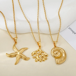Détails de trois pendentifs marins dorés avec étoile de mer, corail et coquillage sur chaînes