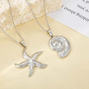 Détail de pendentifs étoile de mer et nautile sur chaînes sur fond de pierre naturelle