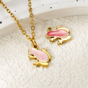 Close-up of golden stainless steel frog pendant with pink enamel and cross chain detail