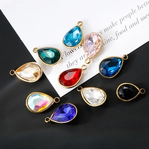 Macro shot of colorful faceted glass teardrop pendants with 18K gold plated metal edges