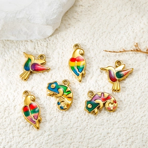 Macro shot of colorful enamel hummingbird and chameleon charms for DIY jewelry making