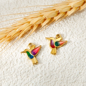 Detailed close-up of colorful enamel hummingbird pendants with gold stainless steel finish