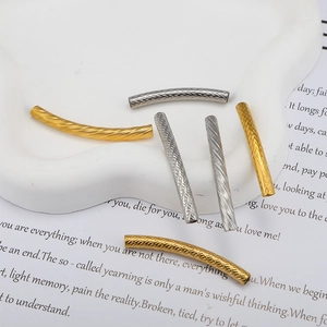Close-up of gold and silver textured stainless steel curved tube beads for DIY jewelry