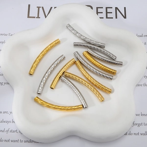 Macro shot of gold and silver curved spacer beads with textured engraving for DIY jewelry