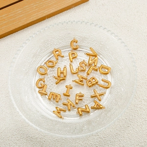 Macro shot of 26 3D bubble letter charms in 18K gold plated steel for DIY jewelry making