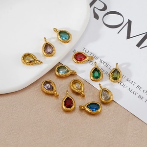 Detailed view of teardrop birthstone charms in various colors on elegant satin fabric