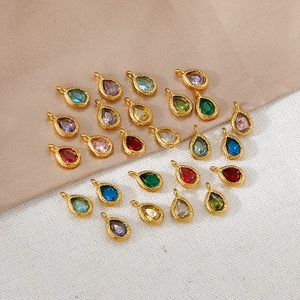 Macro view of teardrop birthstone pendants with gold plated textured frames for DIY jewelry