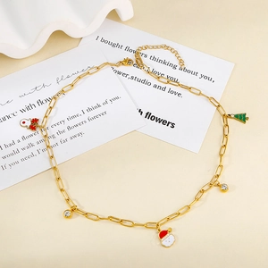 Close-up of gold paperclip chain necklace with colorful Christmas charms and enamel details