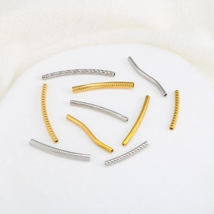 Dettaglio macro di tubi curvi in oro 18K e argento per creazione di gioielli fai-da-te