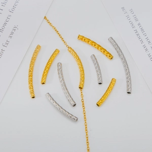 Detailed macro of gold and silver curved spacer beads with textured herringbone engraving