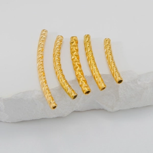 Detailed view of five 18K gold-plated curved spacer tubes with diamond-cut textures for DIY jewelry