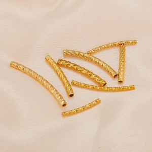 Macro shot of 18K gold plated textured curved tube spacer beads for DIY jewelry making