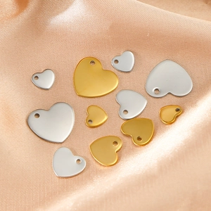 Polished gold and silver stainless steel heart pendants on elegant champagne satin fabric