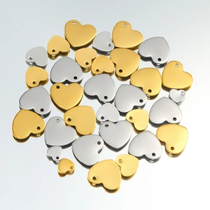 Detailed macro view of gold and silver heart-shaped stainless steel pendant charms for DIY jewelry