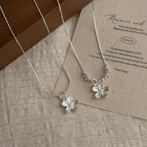Elegant S925 sterling silver matte flower necklaces set on a textured linen surface