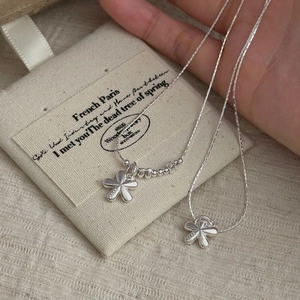 Detailed macro view of S925 sterling silver flower pendant and hallmarked clasp detail