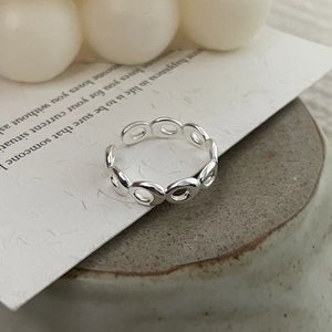 Detail of s925 sterling silver irregular oval chain open ring on textured stone base