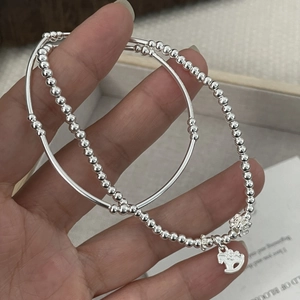Detail of S925 silver beaded bracelet with dainty rocking horse and flower charms