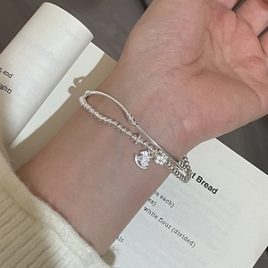 Detail of s925 silver double-layer beaded bracelet featuring rocking horse and flower charms