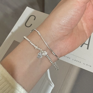 Detail of silver S925 beaded bracelet with horse pendant and minimalist open bangle set