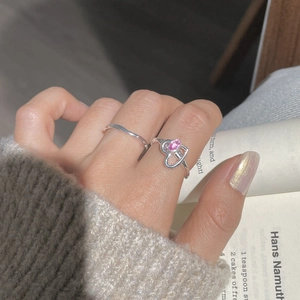 Gros plan sur la bague cœur en argent S925 avec zircon rose et anneau fin superposé