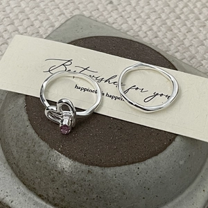 Détails macro d'une bague coeur en argent S925 avec pierre rose et anneau ondulé