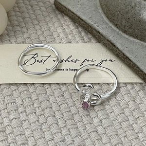 Détail de bague vague en argent S925 et bague cœur évidé avec zircon rose sur carte