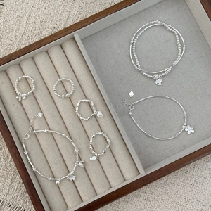 Detail view of S925 sterling silver rings and bracelets set with heart charms in a box