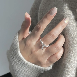 Detailed close-up of S925 sterling silver beaded ring with small charm on finger